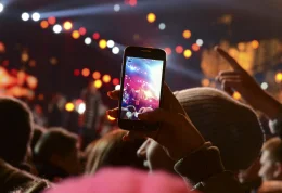 Woman holding up her cell phone at a concert