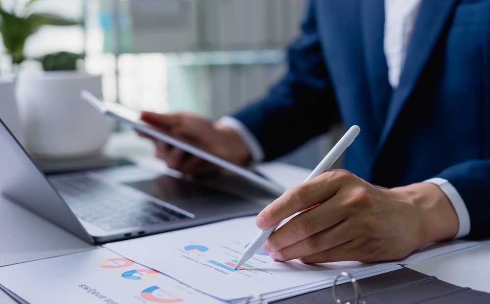 Business professional reviewing analytics on a tablet as BPO improves business efficiency through data-driven operations.