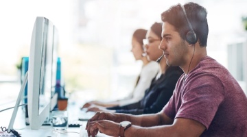 Customer support team working at computers, representing how to effectively manage BPO operations and client service.