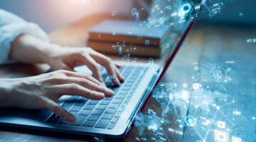 close-up of hands typing on a laptop with futuristic data and network icons overlaid on the screen, illustrating digital transformation and bpo trends to expect in 2026.