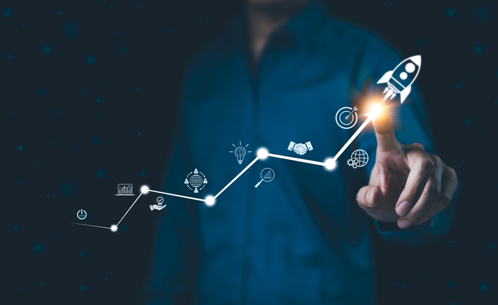 Person pointing to a rising growth chart with a rocket icon, symbolizing business growth and long-term success.