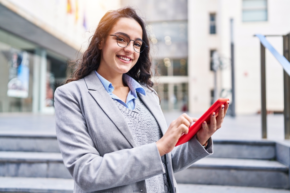 Business professional using a tablet outdoors, illustrating how BPO can help your team stay connected and work smarter.
