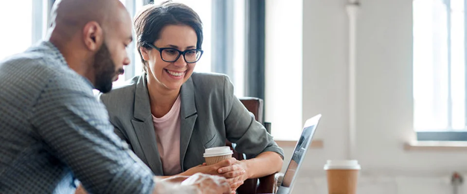 happy business people looking at laptop