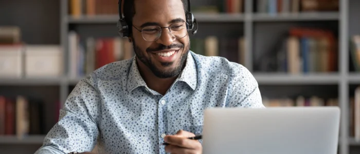 african american man on a call in front of his laptop smiling