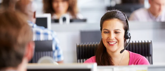 smiling woman working in call center surrounded by agents