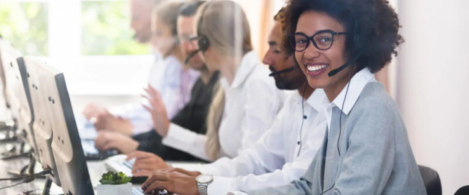 woman smiling with headset on in call center