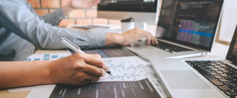 programmer working on laptop taking notes in a BPO during 2021