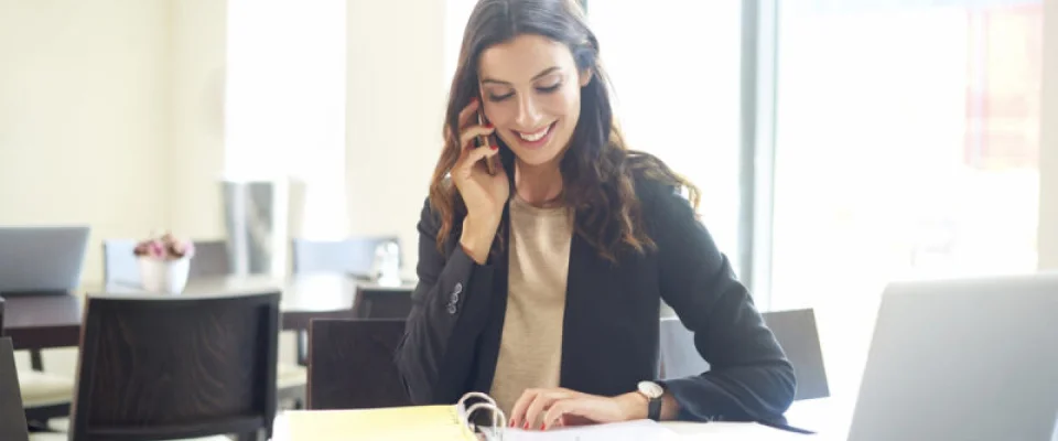 young businesswoman sitting at office desk in front of laptop with BPO benefits