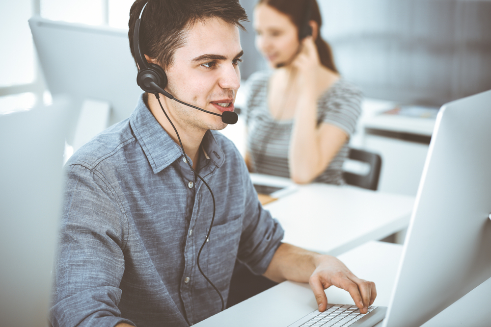 bpo agent working on computer with headset on