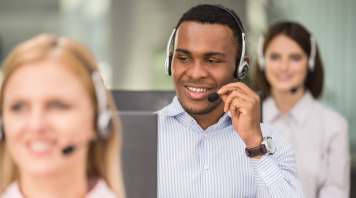 man in call center on phone smiling