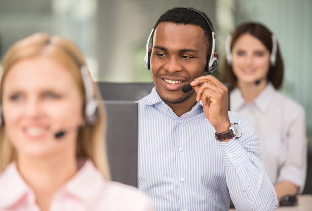 man in call center on phone smiling