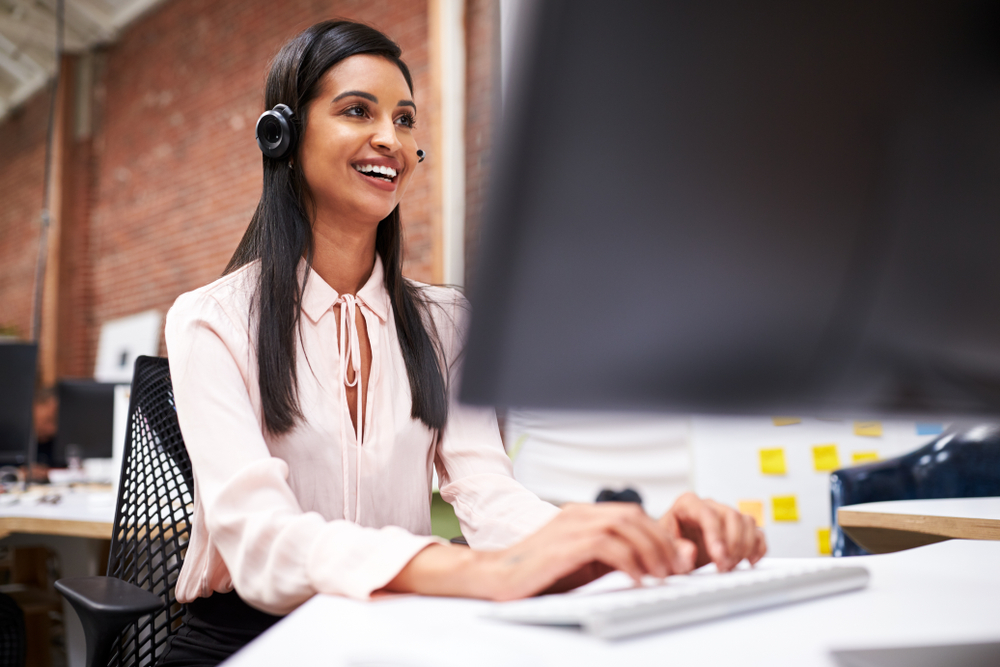 hispanic call center agent on phone in front of computer