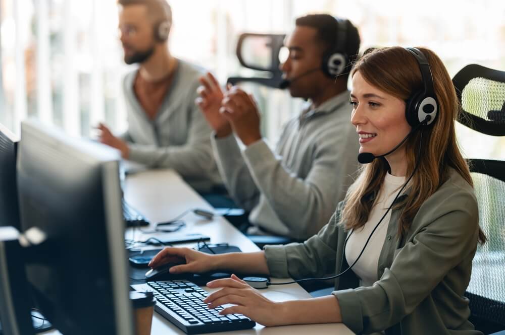 Call center team wearing headsets works at computer stations, showing ways Business Process Outsourcing helps businesses scale faster through reliable customer support.