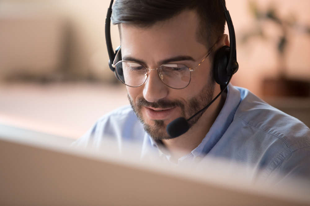 man with head set on in front of computer