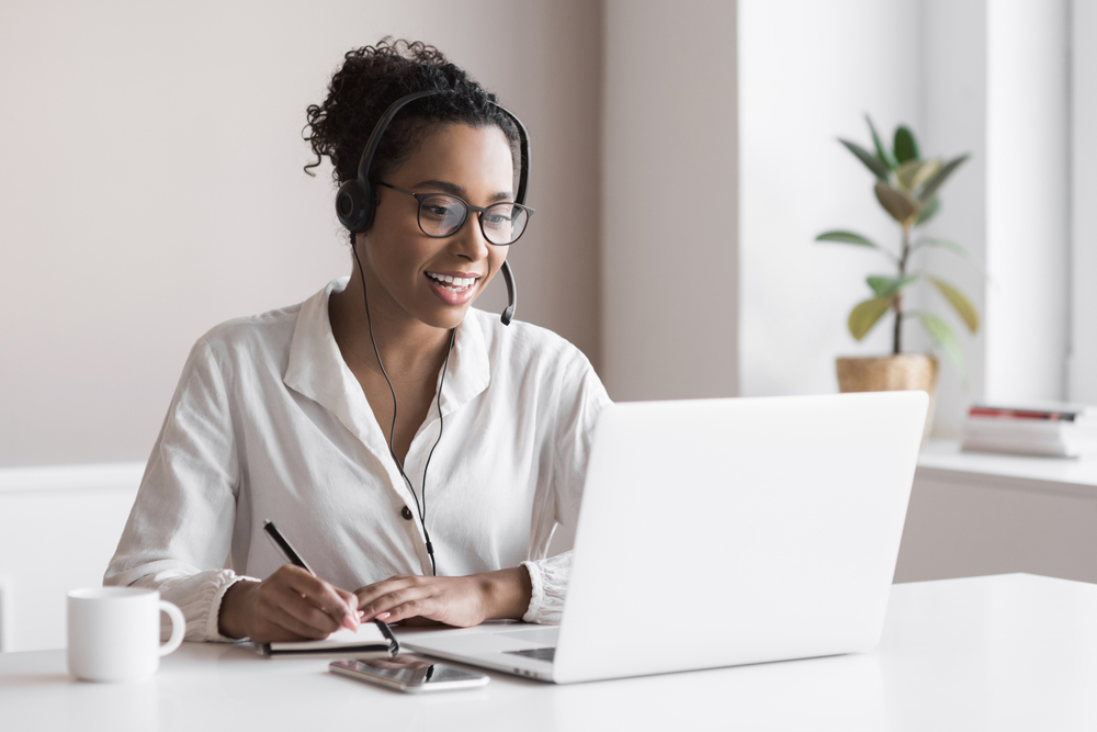 woman on the phone sitting in front of laptop