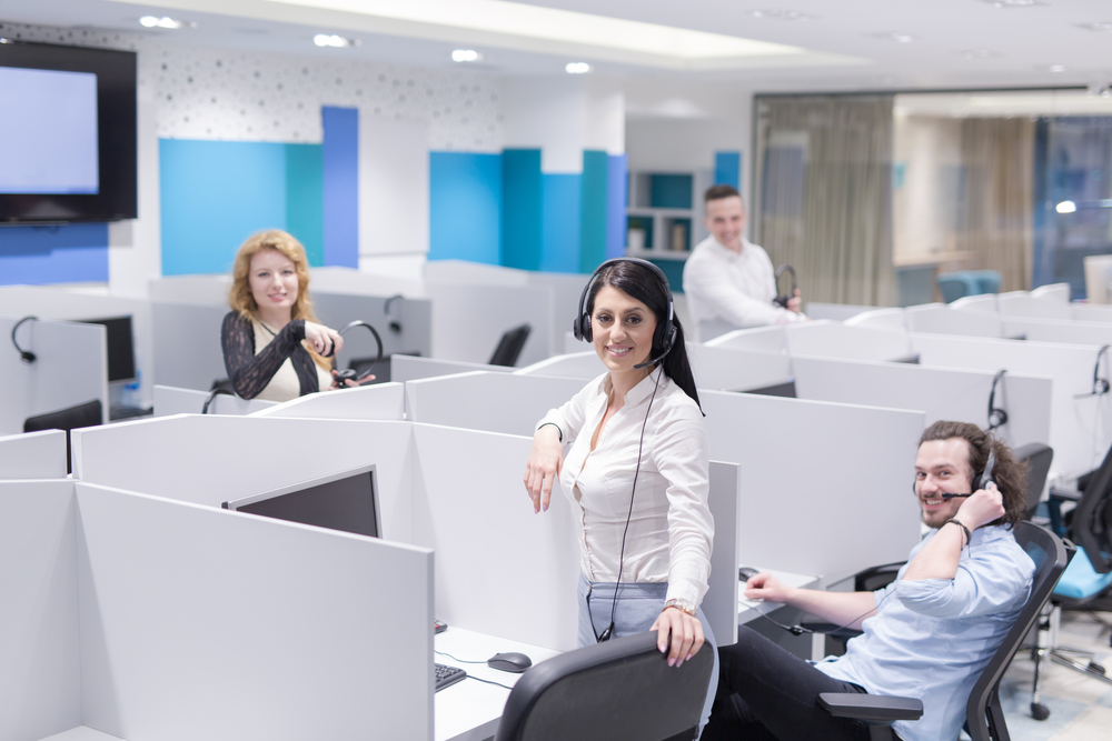 Cheerful diverse call center employees look at camera