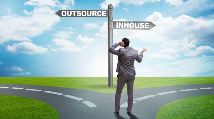 Man stands at crossroads of outsourcing or in-house
