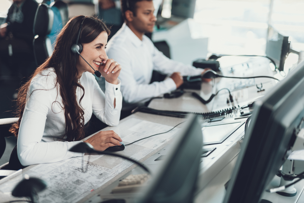 Smiling BPO call center agent talks to customers on the phone