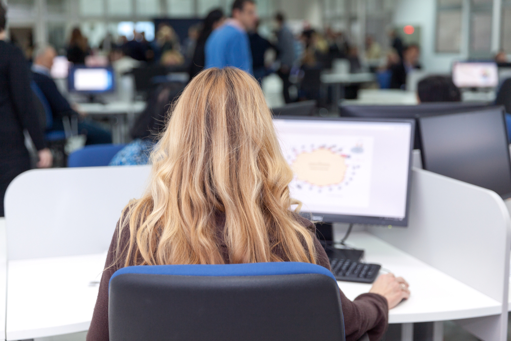 Woman data clerk entering data seen from behind