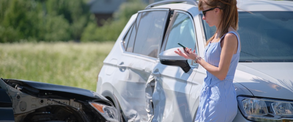 Woman talks on phone to insurance company after an accident.