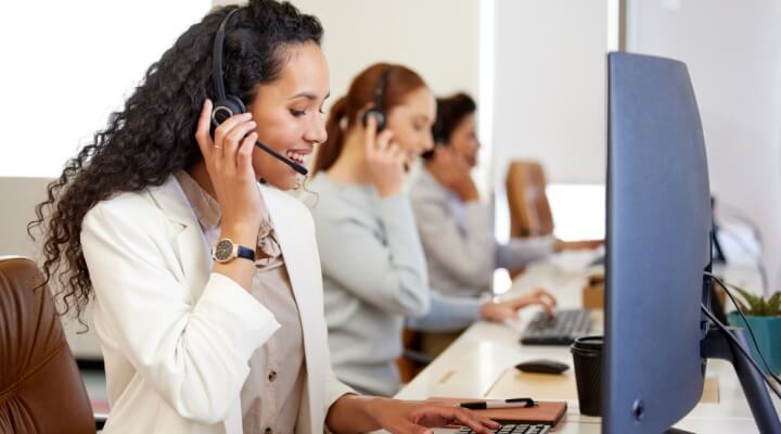 Row of call center agents work with renters and property management companies - best BPO solutions for real estate companies.