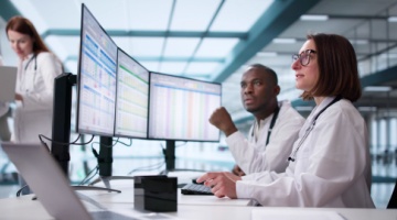 Medical team reviewing patient data on screens in a modern office for outsourcing medical billing services-1