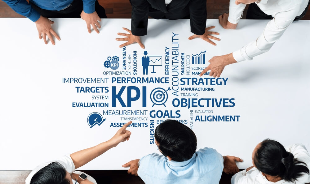 A diverse business team collaborates around a table, discussing key performance indicators (KPI) and strategic objectives of BPO implementation to enhance efficiency and accountability in their projects.