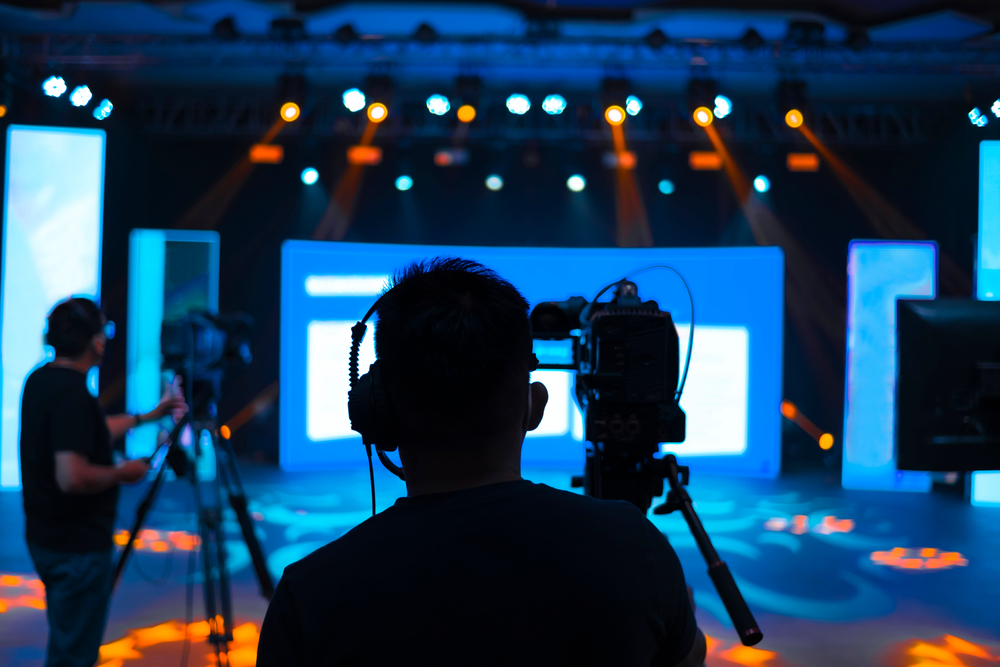 Professional cameraman - covering on event with a video, cameraman silhouette on live studio news, BPO in media and entertainment.