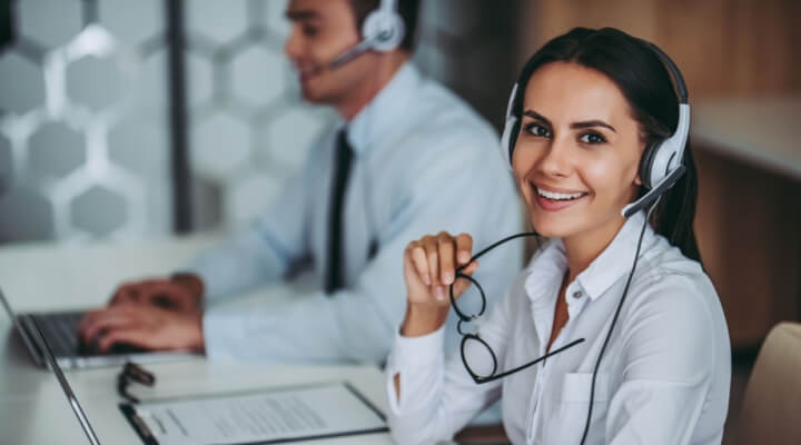 Call center worker in headphones taking calls for outsourced services for businesses.