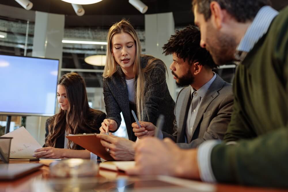 Work team group analyzing different BPO operational models sitting at a table.