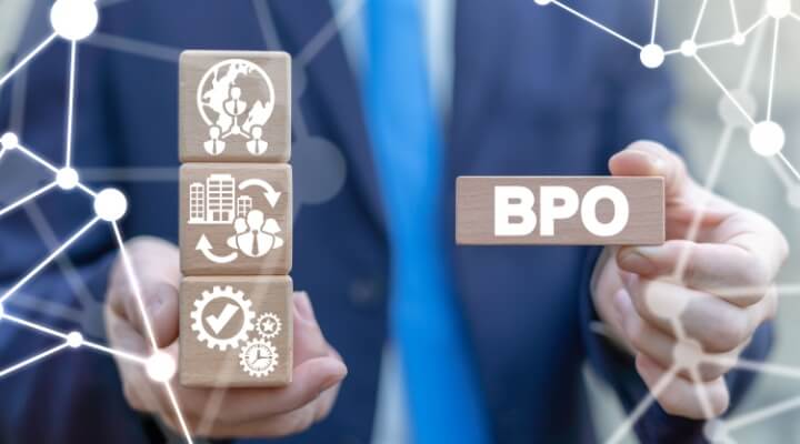 Man in a suit holding wooden blocks with BPO letters representing BPO operational models.