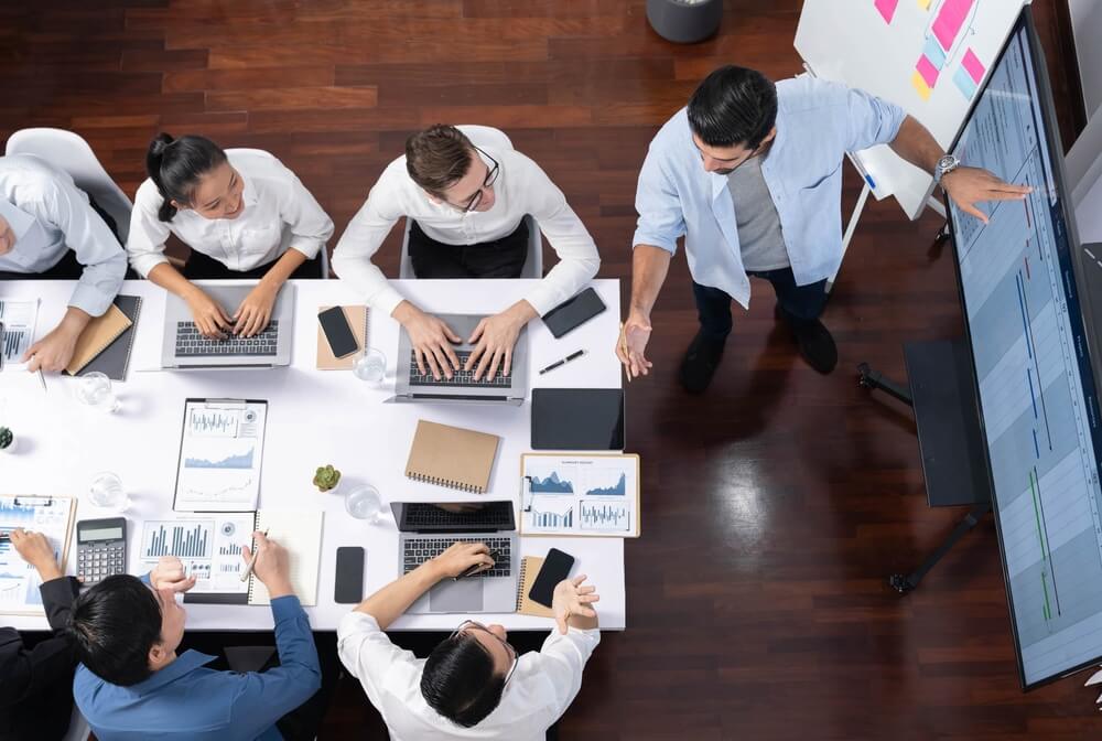 Team reviewing financial data and dashboards during a meeting, representing business payment processing and financial operations