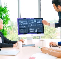 Business team reviewing analytics on a screen during a meeting, highlighting financial efficiency and data-driven decision making.