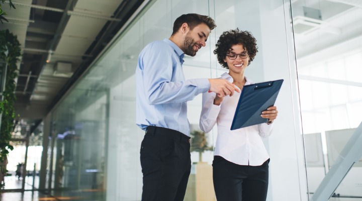 Business professionals reviewing documents together in an office, representing successful outsourcing and team collaboration.-resized-to-720x400