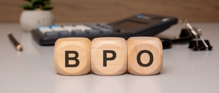 BPO call center concept represented by wooden blocks spelling “BPO” on an office desk.