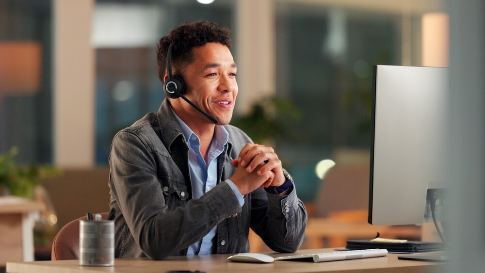 Customer service representative wearing a headset and assisting customers in a BPO call center.