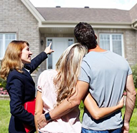 Real estate professional woman shows a home to a couple.