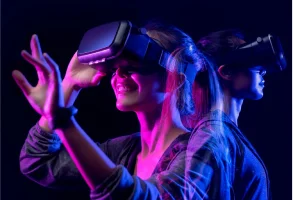 Girl smiling with a virtual reality headset on black background.