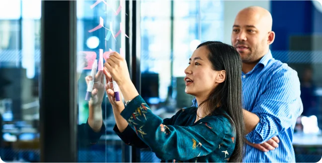 Business woman reviewing notes on a window board