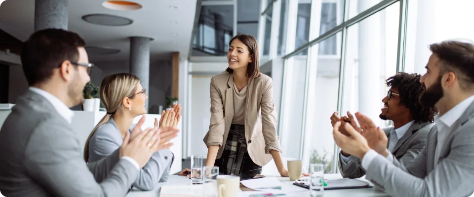 Bussiness woman leading a team meeting with people cheering