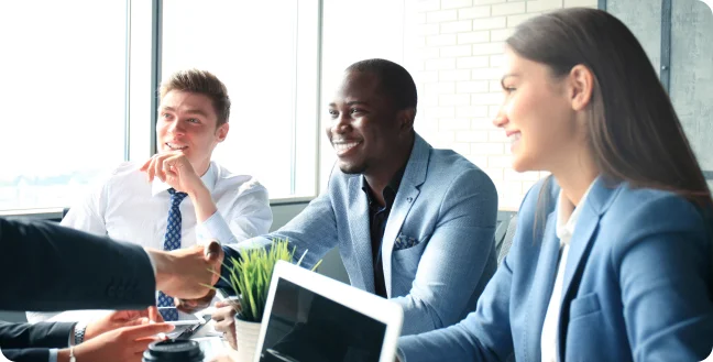 Three coworkers smiling in an meeting