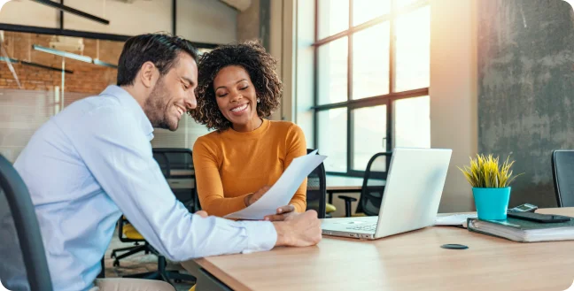 Co-workers reviewing papers in sunny office