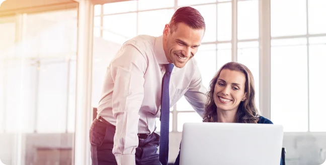 Two professionals looking at a laptop