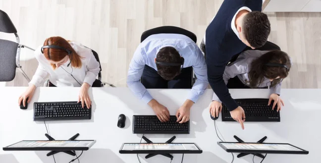 Upper view of three call center agents and a supervisor in an office.