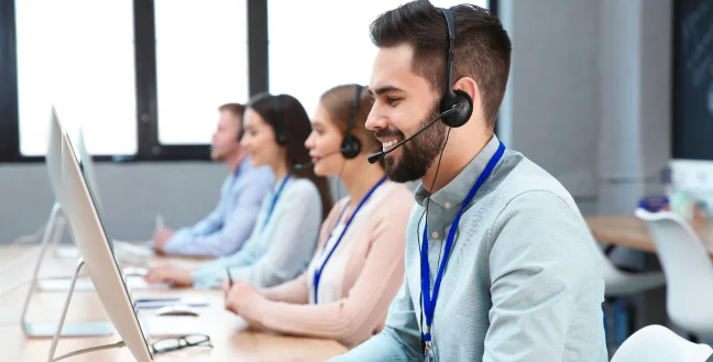 Group of agents smiling while answering customer service calls